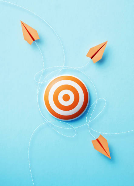 istock Paper Planes Flying Around An Orange Bull's Eye Target On Blue Background 1471492951