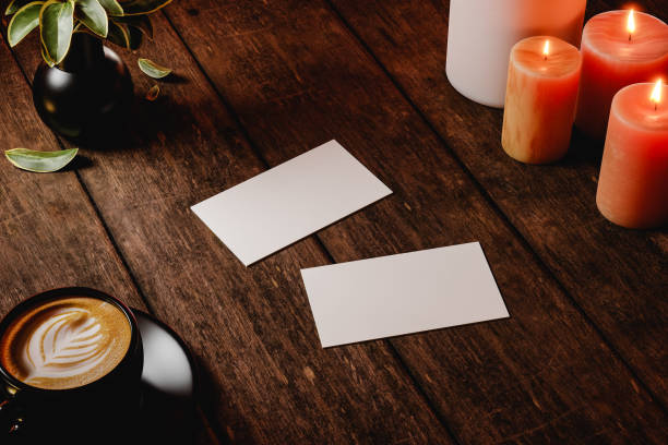 Two business cards on wooden rustic table, near coffee and candles. Template for branding identity. 3d render