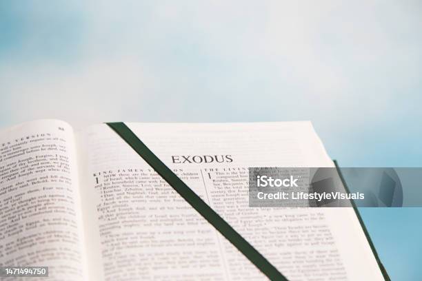 Open Bible To The Book Of Exodus In The Old Testament Blue Sky With White Clouds In Background Dark Green Satin Ribbon Marks The Page Stock Photo - Download Image Now