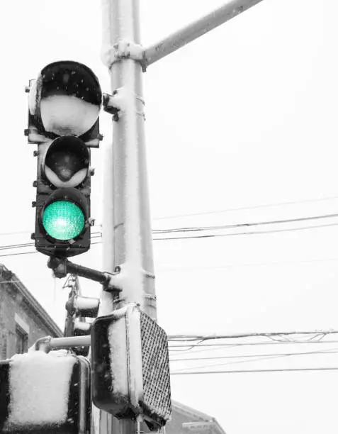 Snow covered stoplight in black and white during a snowstorm