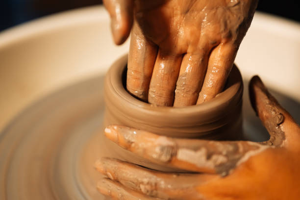 istock Close up on skillful hands sculpting pottery jar on potter wheel 1471498136