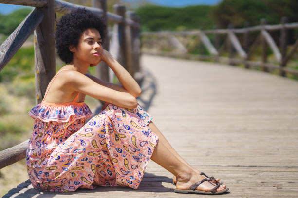 istock Thoughtful black woman sitting on boardwalk 1471501362