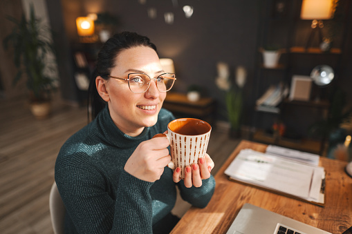 White woman with black hair having a coffee break while working from home