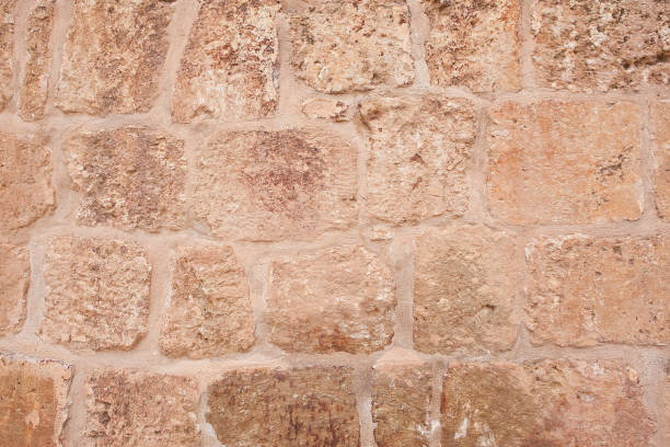 Stone and Brick Wall Texture. Old natural stone wall background. A fragment of a city wall of hewn stone on cement mortar. Stones of different sizes and colors. Stone and Brick Wall Texture. Old natural stone wall background. A fragment of a city wall of hewn stone on cement mortar. Stones of different sizes and colors. roughhewn stock pictures, royalty-free photos & images