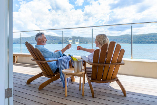 Mature couple drinking wine out on the deck. stock photo