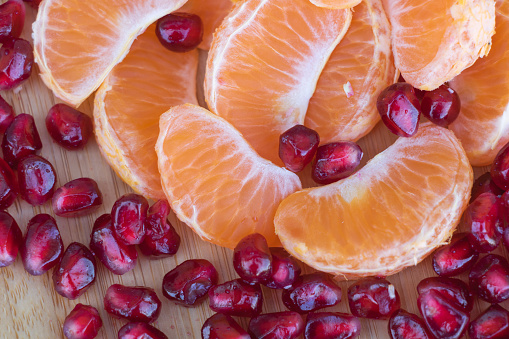 Healthy and Delicious: Tangerines and Pomegranates on a Wooden Surface.