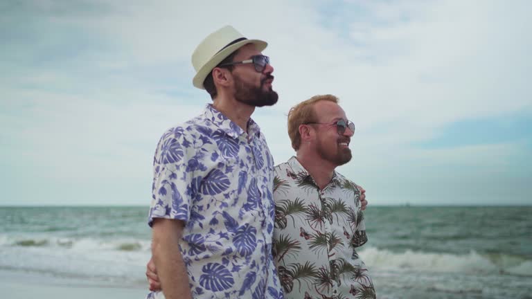 Gay couple walking along the beach