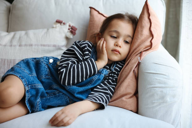 Sick little girl coughing on sofa