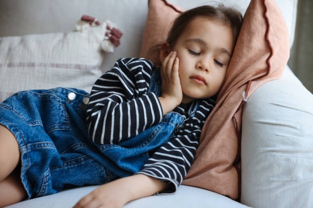 istock Sick little girl coughing on sofa 1471518344