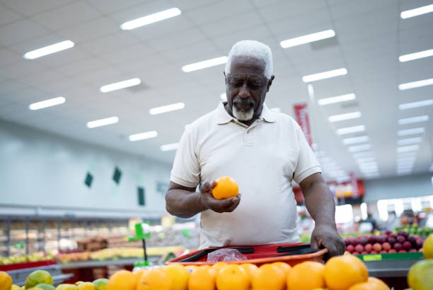 Senior man choosing oranges in the supermarket