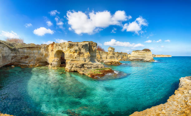 Stunning seascape with cliffs rocky arch and stacks (faraglioni) at Torre Sant Andrea
