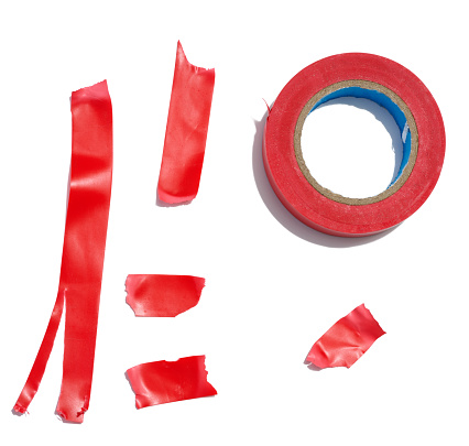 Various pieces of red duct tape and a roll of duct tape on a white isolated background, a repair item
