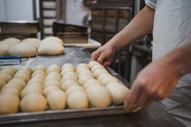 istock Baker holding a tray full of bread dough 1471521208