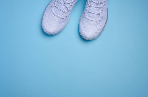 istock White textile sneakers on a blue background, top view 1471521401