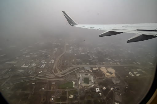 View of Birmingham, Alabama disappearing into the fog from the Window of a Commercial Airline Flight from Birmingham Airport to Baltimore/Washington International Airport