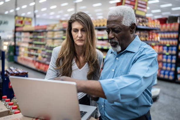 istock Coworkers talking while using the laptop in the supermarket 1471522306