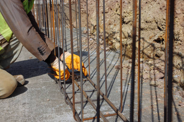 Construction workers on a construction site. High angle view of  people with helmets. Rebar - foundation of the building.