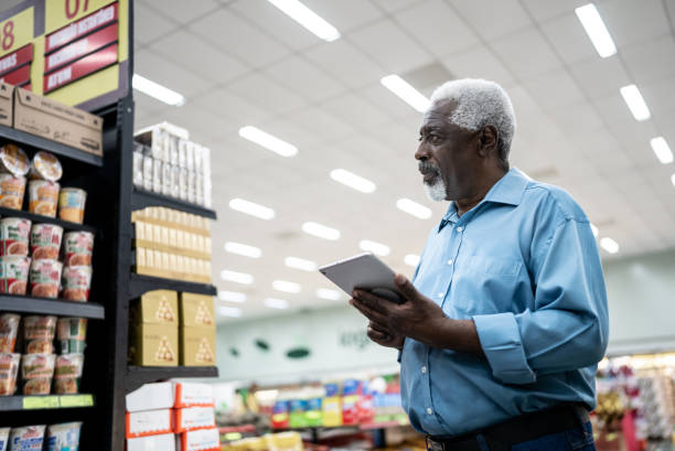 istock Senior man working on the digital tablet in the supermarket 1471522500