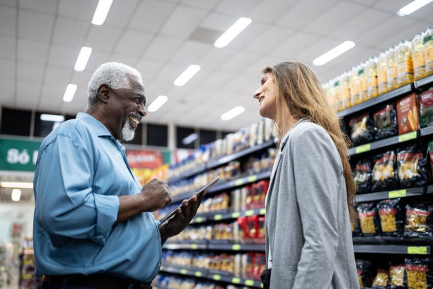 istock Coworkers talking and using the digital tablet in the supermarket 1471522502