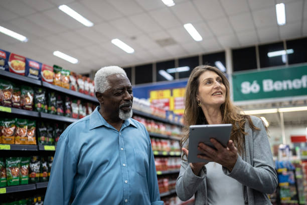 istock Coworkers talking while using the digital tablet in the supermarket 1471522869