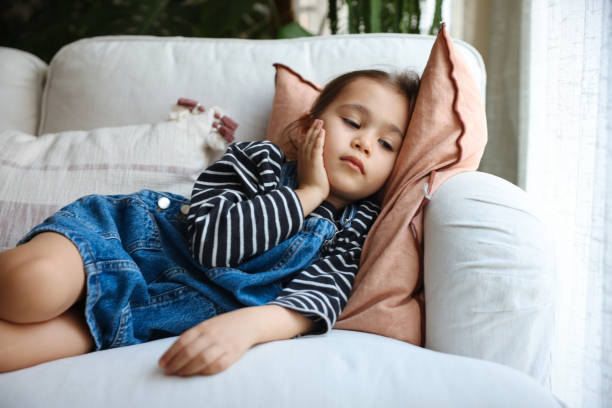 istock Sick little girl coughing on sofa 1471522874