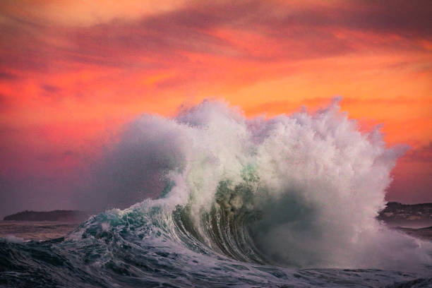 istock Powerful display of ocean waves colliding creating water explosion in dramatic pink and gold sunset light 1471530674