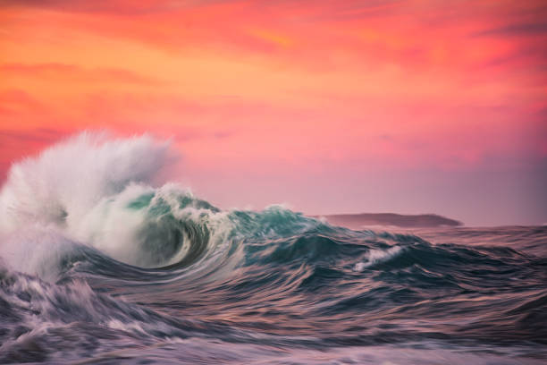 istock Powerful display of ocean waves colliding creating water explosion in dramatic pink and gold sunset light 1471530677