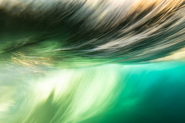 istock An abstract artistic scene of a wave breaking underwater in dramatic golden light 1471530735