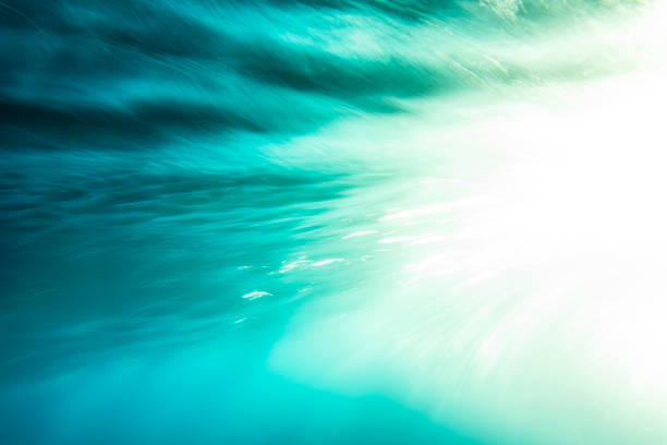 An abstract artistic scene of a wave breaking underwater in dramatic golden light. Photographed with slow shutter in camera technique.