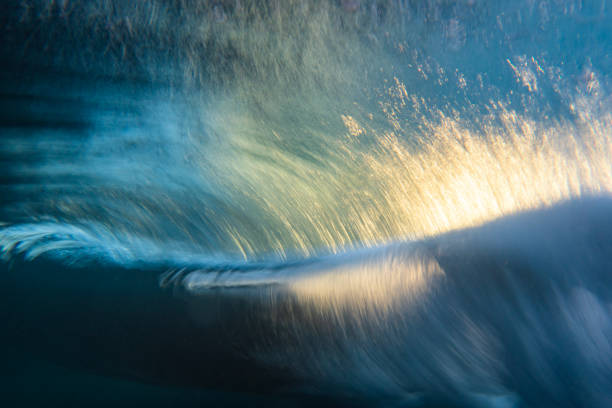 istock An abstract artistic scene of a wave breaking underwater in dramatic golden light 1471530795