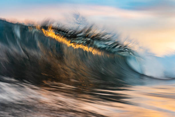 istock An abstract artistic scene of a wave breaking in dramatic golden light 1471530841