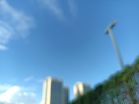 Shoot photo in blurry mode for blue sky, building and hedges