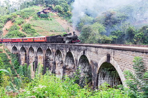 Ella, Sri Lanka - February 13, 2020: Steam train on the Nine Arches Demodara Bridge in Ella
