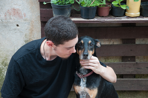 young man with his dog in the backyard of the house, lifestyle people concept