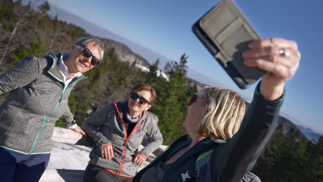 SLO MO Three older women taking a selfie on the mountain top