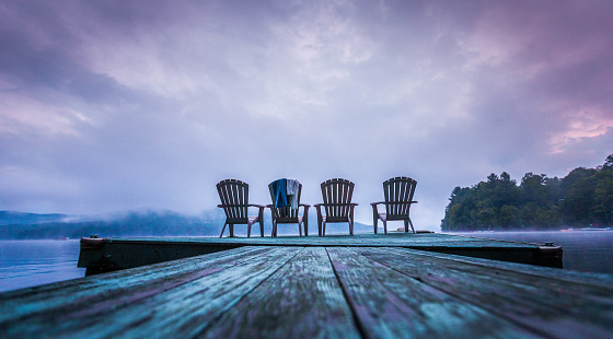4 chairs sit on a painted dock on Lake Sacandaga in Upstate New York