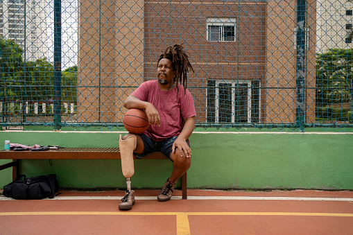 Man with leg prosthesis playing basketball
