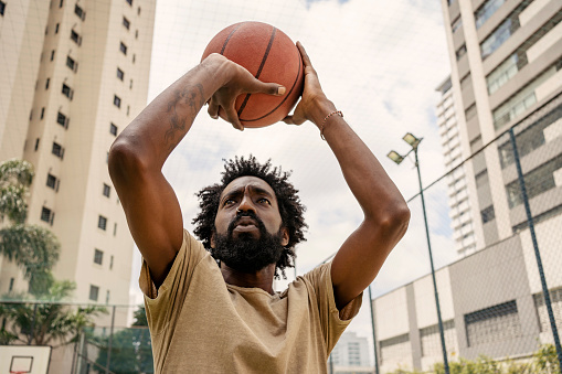 Black man training basketball free throw