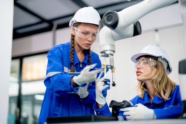istock Two professioan technician or engineer with one sit and other hold tablet discuss about function and mode of work of factory robotic arm machine in workplace. 1471554265