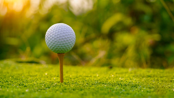 istock White Golf ball on tee on green grass of golf course with copy space 1471554417