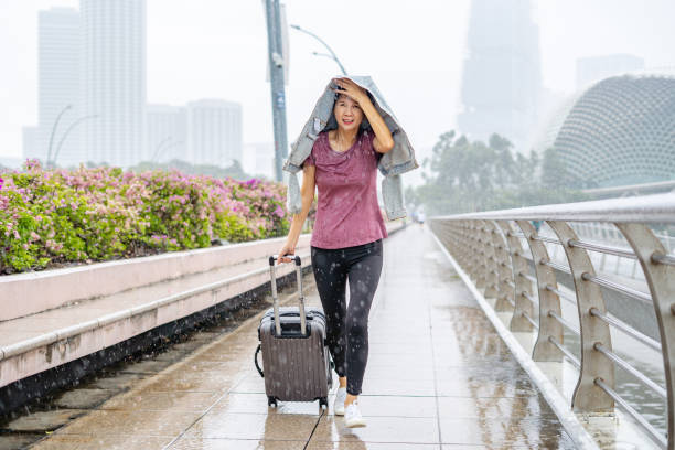 Travelling woman looking upset with heavy rain.