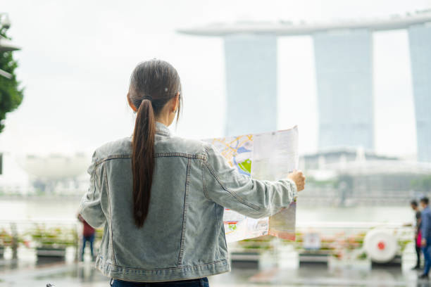 Tourist searching location in a paper map.