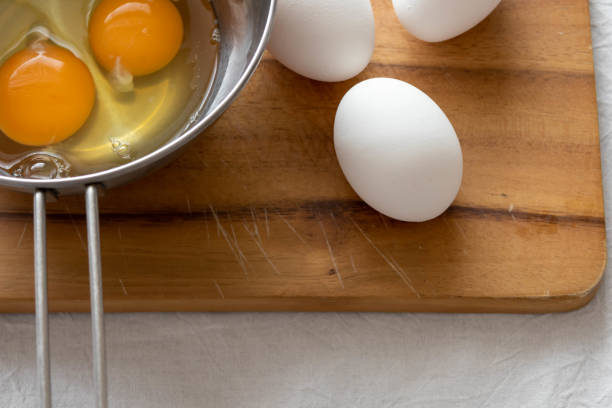 istock A raw egg on a cutting board and a cracked raw egg in a bowl 1471555219