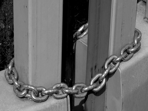This photo was shot in late November 2022  on an industrial district Dusseldorf, Germany. Here is depicted in close-up, a chain locking the main entrance gate to a facility, recently deactivated.