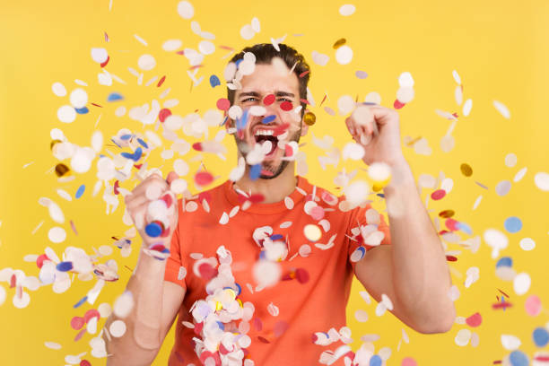 istock Happy man surrounded by confetti flying in the air 1471565501
