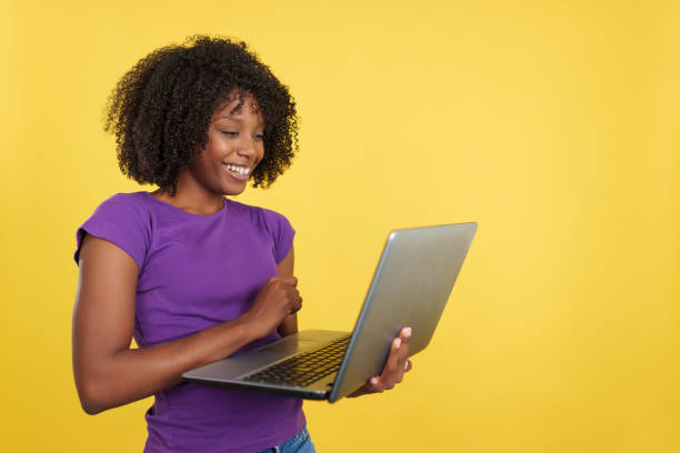 istock Woman with afro hairstyle smiling while using a laptop 1471565558