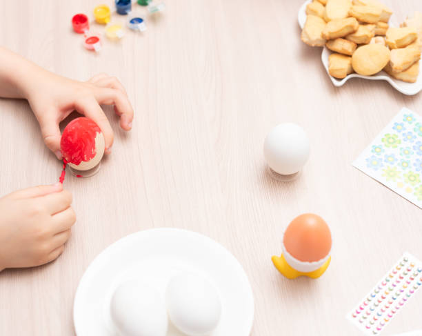 istock Child hands painting easter eggs, selective focus. Happy Easter concept. Process of crafting at home. Greeting card with copy space 1471570462