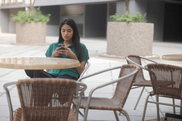 istock Young Indian woman using digital technology outdoors at a restaurant 1471570717