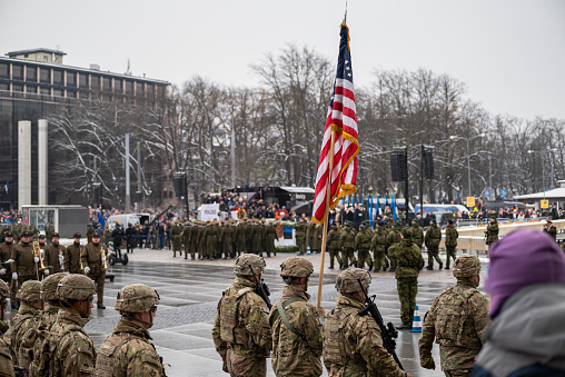 Estonia's NATO ally - United States military armed forces holding the US flag in the Tallinn main square marching in the parade celebration of independence