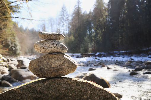 Pebble tower or rock pyramid. Concept for relaxing, zen, spiritual or yoga. Nature background. Selective focus on rocks.
